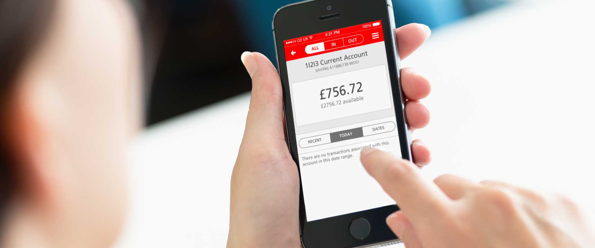 picture of a woman holding an iphone with the santander mobile banking app on the screen
